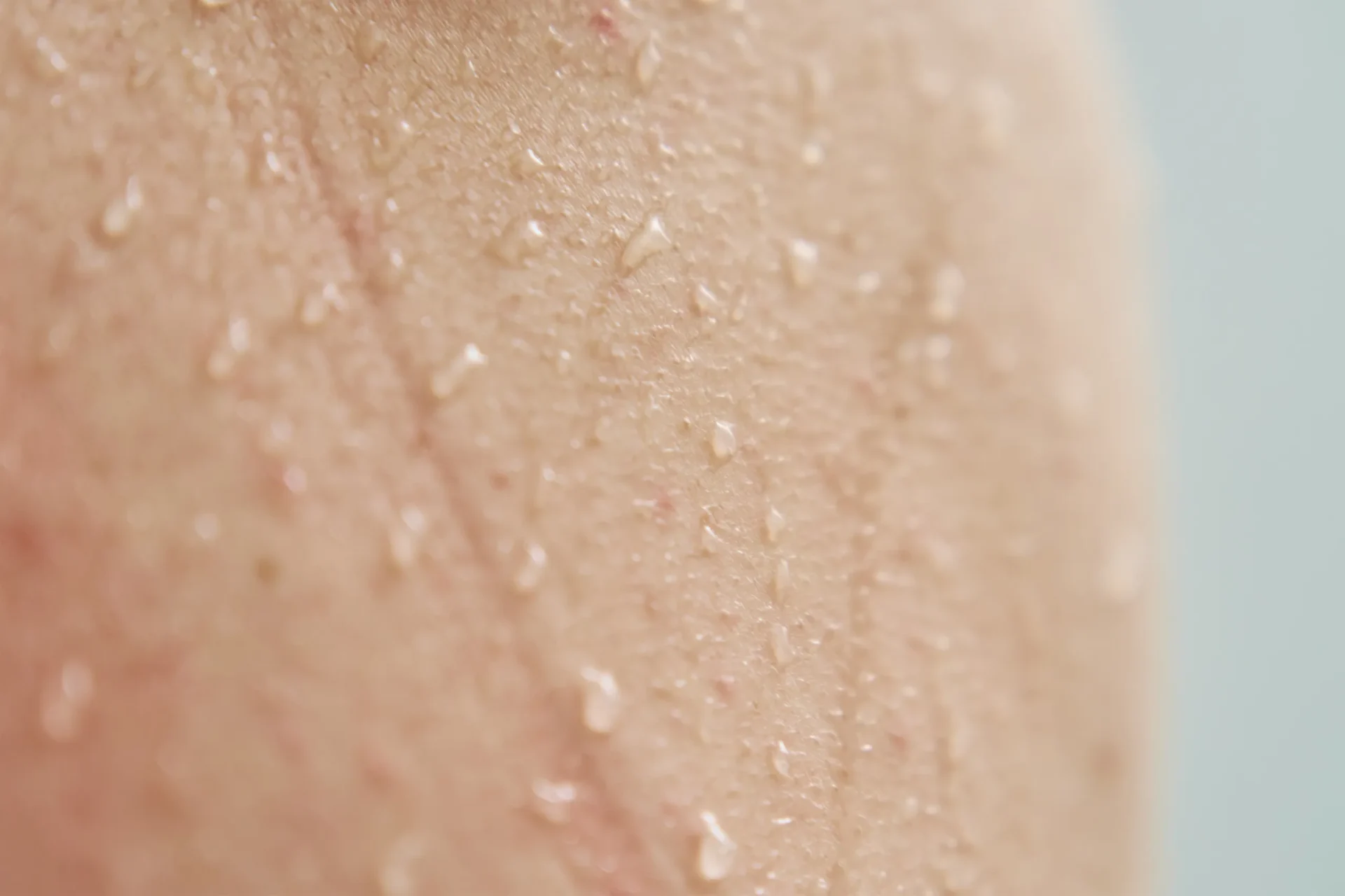 98007228 female body skin with water drops in shower